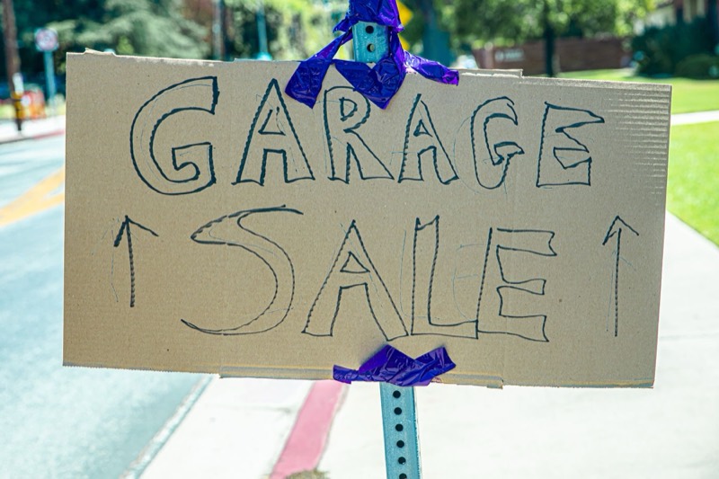 A handwritten Garage Sale sign taped to a street post